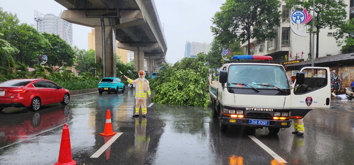 Cảnh sát giao thông khẩn trương phân luồng, dọn cây đổ giúp người dân tham gia giao thông